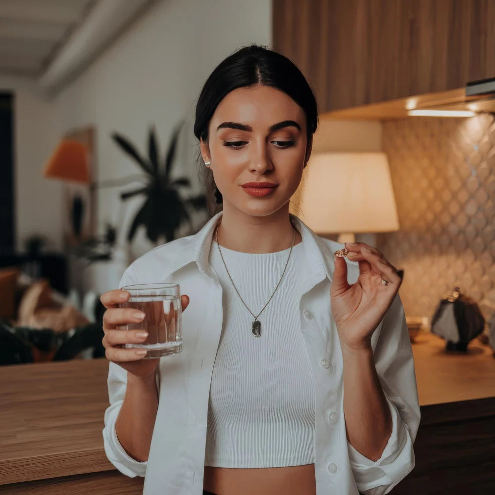 Morning light on a glass of water, one capsule and a small dish of sliced astragalus root.