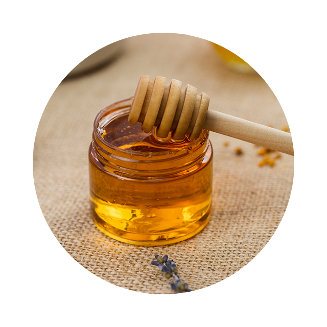 Manuka honey with wooden dipper representing skin-soothing hydration.