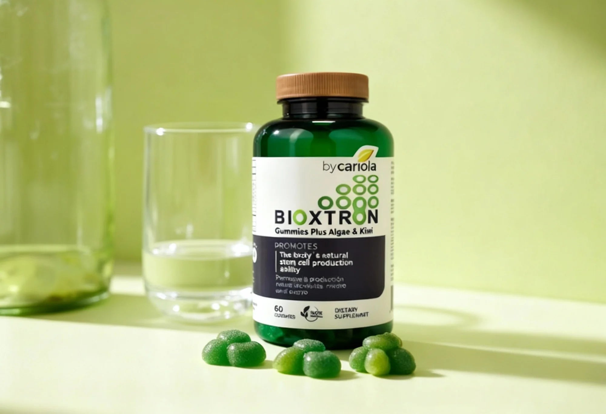 Bottle of Bioxtron Stem Cell Boost Gummies with a few gummies beside it and a glass of water, showing recommended daily use.

