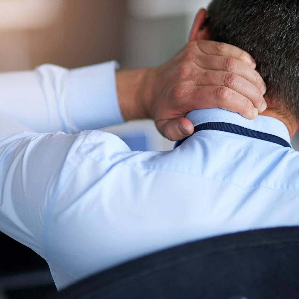 Man applying Army Health cream at work to ease back and neck tension midday.