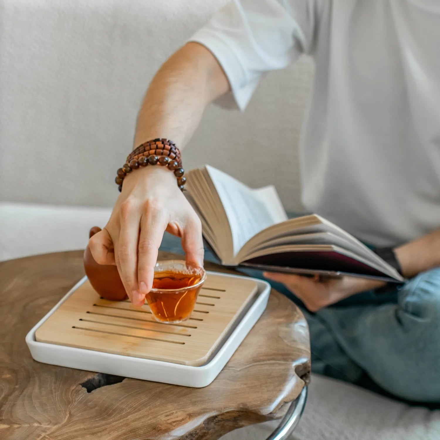 Evening routine scene with herbal tea and a person taking a supplement capsule.