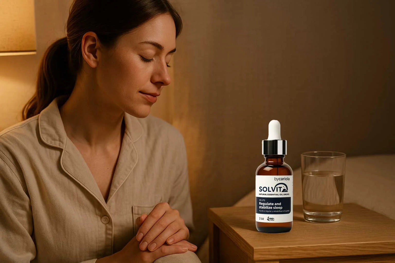 Woman in a minimalist bedroom with warm lamp light, Solvit Sleep Drops dropper next to a glass of water on a nightstand.
